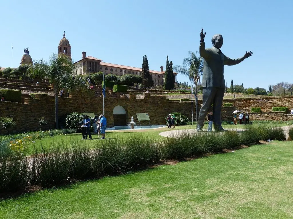 A photograph capturing the vibrant atmosphere of Nelson Mandela Square in South Africa, illustrating the intersection of employer of record, payroll, recruitment, workforce management, and manpower services in a bustling urban environment. The image showcases diverse individuals engaging in various activities, symbolizing the multifaceted nature of employment and human resource management in the heart of South Africa's cultural and economic hub